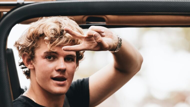 Teenager saying good by driving in car